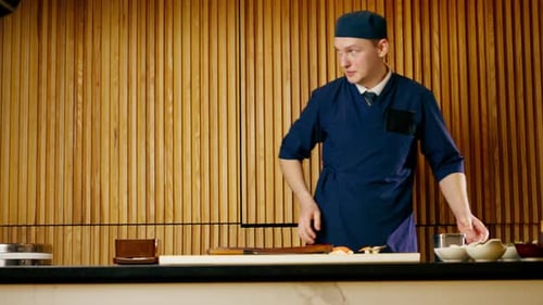 in Japanese Restaurant the Chef Lays Out Pieces of Raw Fish on a Long Red Plate