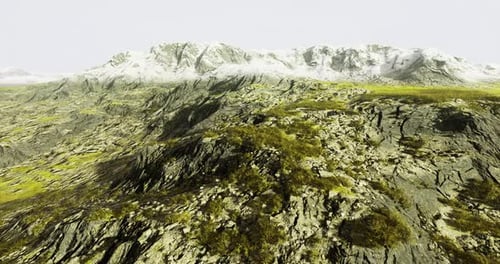 Mountain Landscape with Rocky Terrain and Snow Capped Peaks at Dusk