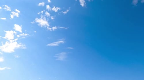 Blue sunny sky clears up from white clouds. Light spindrift clouds flying quickly