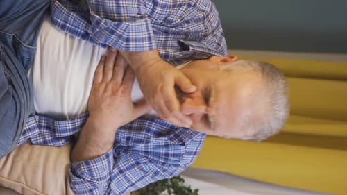 Vidéo verticale d'un vieil homme malade qui tousse.
