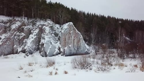 A Picturesque Winter Landscape Displaying Beautiful SnowCovered Rocks Surrounded By a Dense Forest