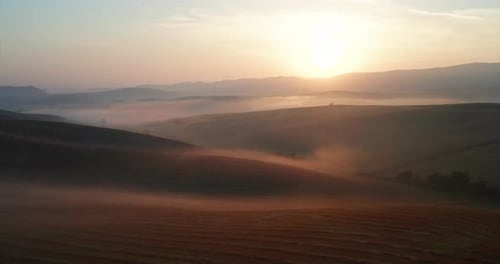 Aerial shot of scenic panoramic misty view of Italian hills at a sunrise.