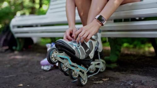 Teenager Girl Remove Inline Roller on Bench After Skating in Public Park