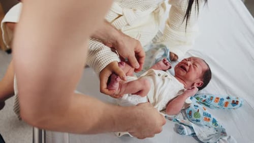 Multiethnic Couple Holding and Admiring Their Newborn Baby in Hospital in Post