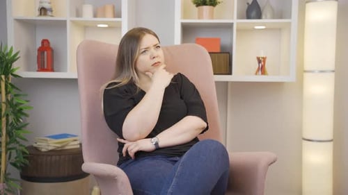 Worried Woman Sits Thinking in Bright Room