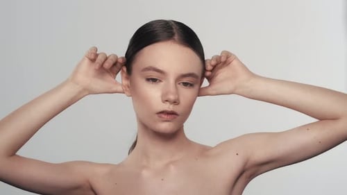 Attractive Female Model Touching Her Face and Smooth Skin Looking at the Camera