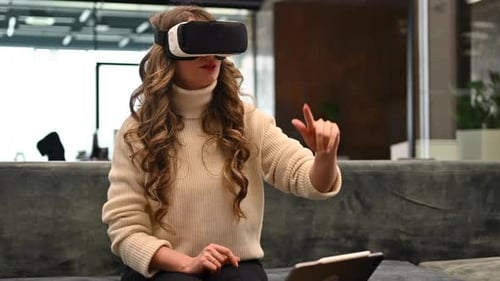 Happy woman working with VR virtual reality set on head at the office