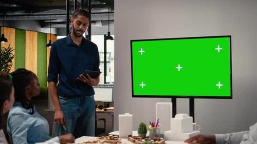 Diverse Engineering Staff Study Zoning Regulations Next to Green Screen on TV