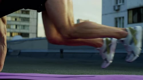 On the Roof of the City the Athlete Concentrates on Exercising All Muscle Groups