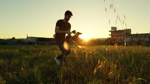 Video Operator with Cinema Camera in Action Outdoor at Sunset Light