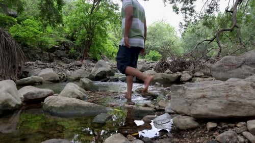 Isolated Man Relaxing by Peaceful River Stream in the Morning