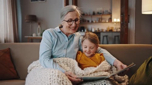 Senior Adult and Child Reading a Book Together