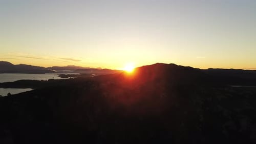 Aerial Sunset Over Fjord – Vibrant Sky Reflected on Water with Mountain Landscape in 4K