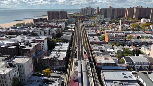 Luftaufnahme eines Stadtviertels mit Bahngleisen, Straßen und lebendigen Farben ist in Brighton Beach