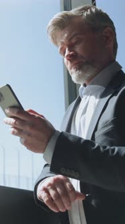 Portrait of Goodlooking Business Manager Holding Smartphone in Hands Chatting Footage of Handsome
