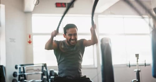 Man, workout and battle rope at gym for muscle, development and power with training for growth