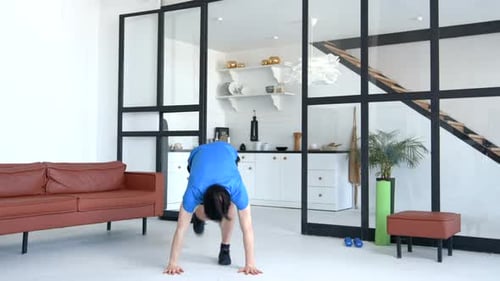 Sportlich fitter, gutaussehender Mann, der zu Hause Burpees-Training übt