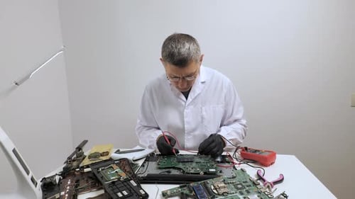 Técnico que repara la placa base de una computadora con un multímetro