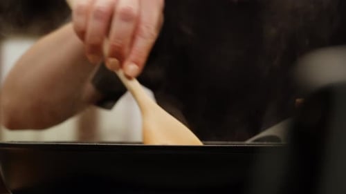 Wooden Spoon Stirring Vegetables Cooking in Pan