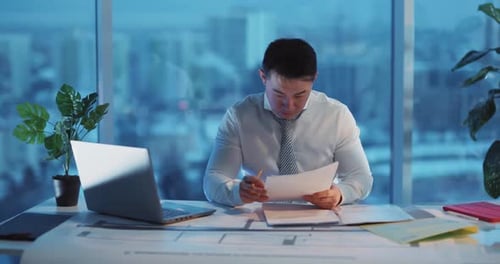 Dedicated and Focused Professional Working Late Into the Night in a Modern Office Setting