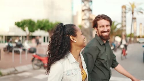 Closeup, happy interracial couple going down the cross the road holding hands and chatting