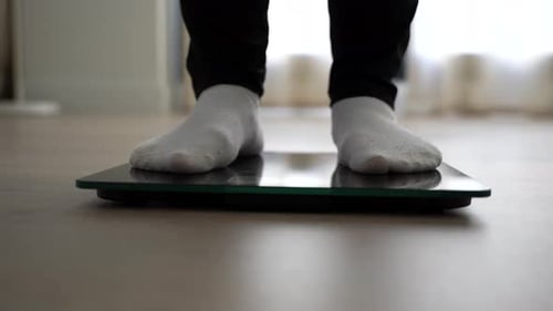Female feet stepping on and off a scale twice