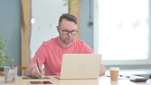 Young Adult Drawing on Tablet in Office