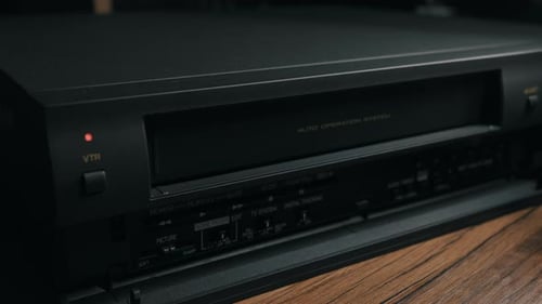 Hand Inserts VHS Tape Into Retro VCR Player