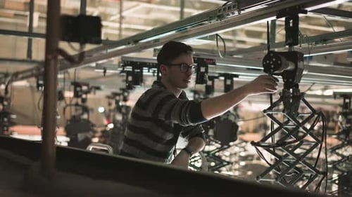 Technician Adjusting Studio Lighting Rigging Equipment