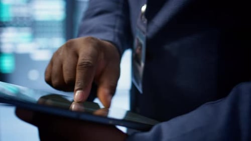 Close Up Shot of Man Using Tablet in Data Center Ensuring Rigs are Functioning