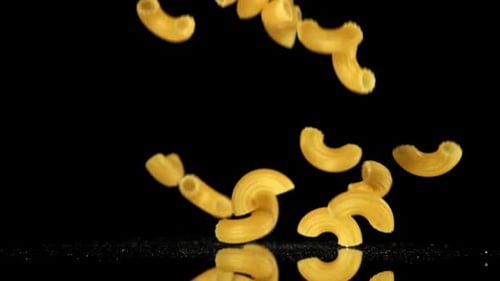 Elbow Macaroni Pasta Falling in Slow Motion on Black