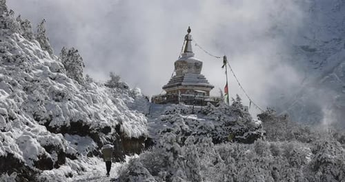 People porting goods to the mountains in Nepal along a snowy trail.