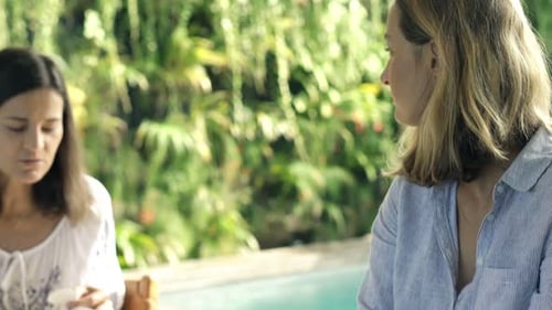 Two Girlfriends Talking Sitting by Table in Garden Adult