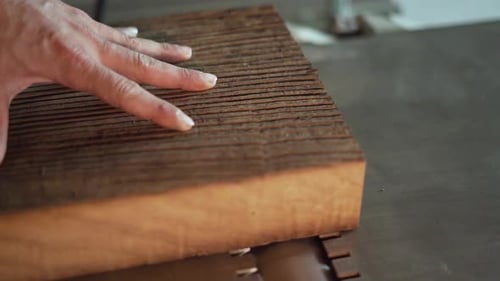 Hand Guiding Wood Across Industrial Machine