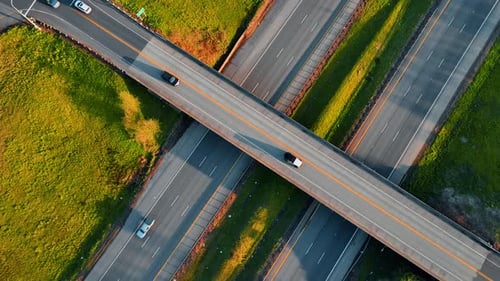 Autoestrada acima de duas rodovias no campo. Vista superior das estradas com carros em movimento