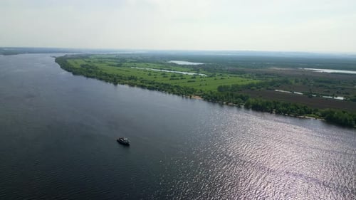 Cargo Ship Navigating Wide River on Sunny Day Clip