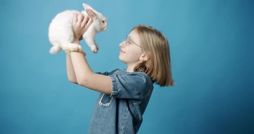 Child Holds Fluffy White Rabbit Lovingly