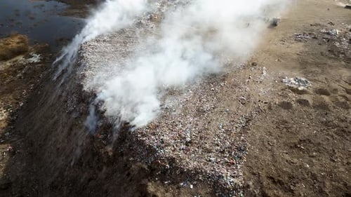 Aerial view of landfill with burning trash piles