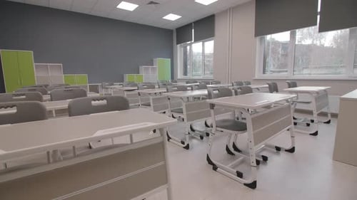 Escritorios y sillas para estudiantes y estantes en un aula vacía