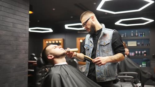 Barber Trimming Client's Beard in Modern Barbershop