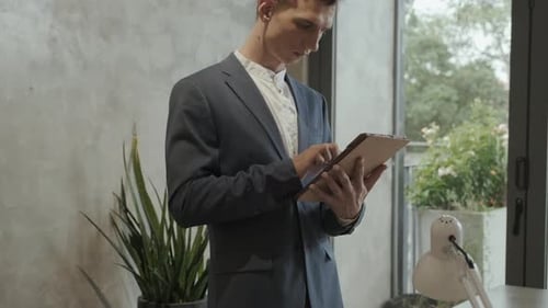 Young Adult Using Tablet in Modern Office