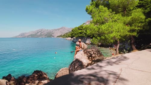 Woman relaxing on beach during summer vacation. Picturesque seaside, clarity of the Adriatic Sea mee