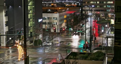 Scene At The City With Single Car Driving On The Wet Asphalt Road On A Rainy Night. - wide shot