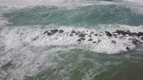 Powerful Ocean Waves Crashing Against Rocky Breakwater