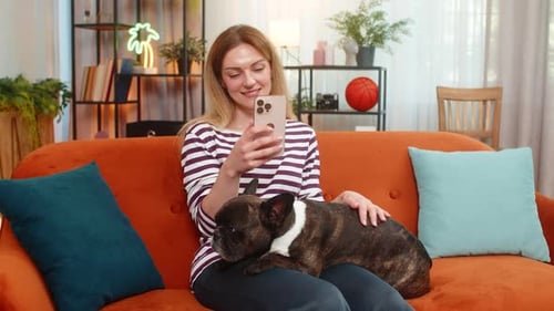 Woman Relaxing on Couch with Dog and Phone
