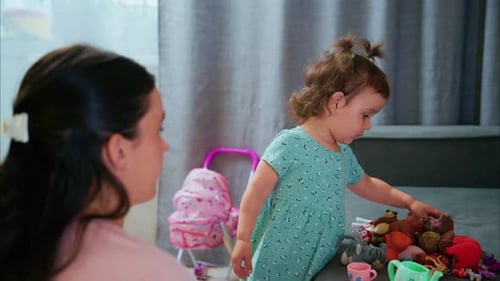 Woman and child play with toys on sofa indoors