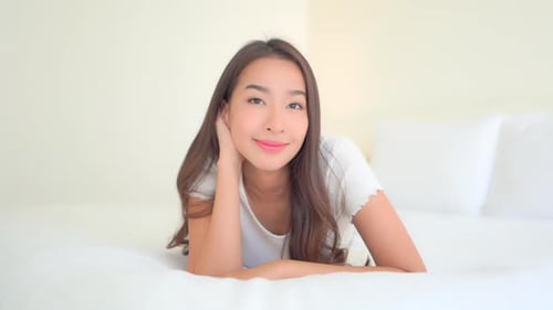 Beautiful Woman Relaxing in Bed, Smiling Portrait