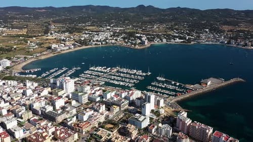 Aerial drone footage of a beach in the village of Sant Antoni on the island of Ibiza in Spain