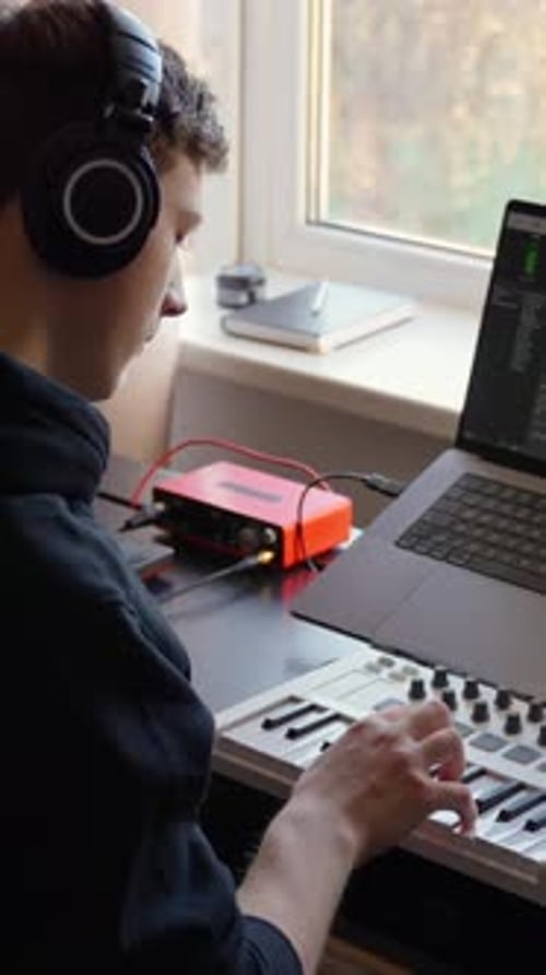 Vertical Close-Up of Musician Using MIDI Keyboard in Home Studio