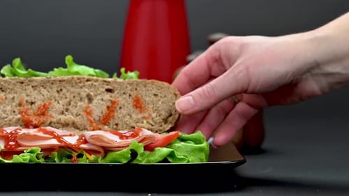 Hand Placing Top Slice of Bread on Sandwich